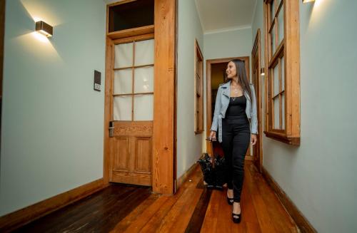 a woman is walking down a hallway at Hotel Baquedano Boulevard in Iquique