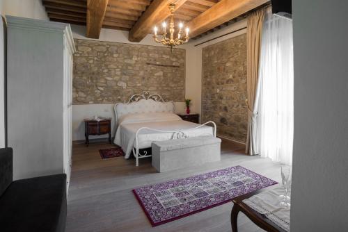 una camera con un letto bianco e un muro in pietra di Ca' Maggio a Sasso Feltrio