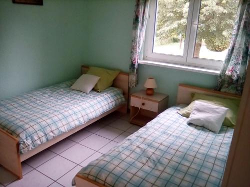 two twin beds in a room with two windows at Les gîtes du lindenberg in Dambach
