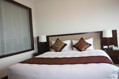 Кровать или кровати в номере Muong Thanh Luxury Song Lam Hotel