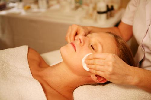 a woman getting her face washed with a bottle of soap at Gudbrandsgard Hotel in Kvitfjell