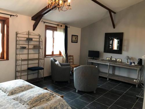 a bedroom with a bed and a desk and chairs at Ferme de la Forterie in Verlinghem