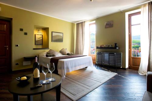a bedroom with a bed and a table with wine glasses at Casa Svizzera Agriturismo in Barolo