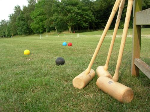 a group of four baseball bats and balls on a field at Aslan in Chipping Norton