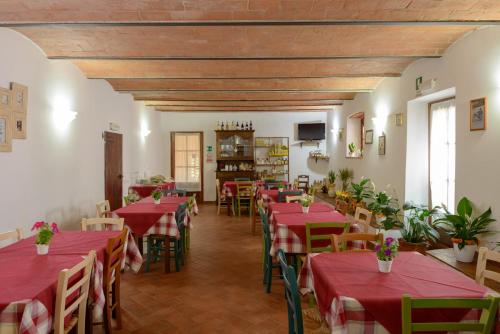 a restaurant with red tables and chairs in a room at Agriturismo Pretenzano in Volterra