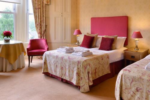 a bedroom with a large bed with a pink headboard at Craigroyston House in Pitlochry