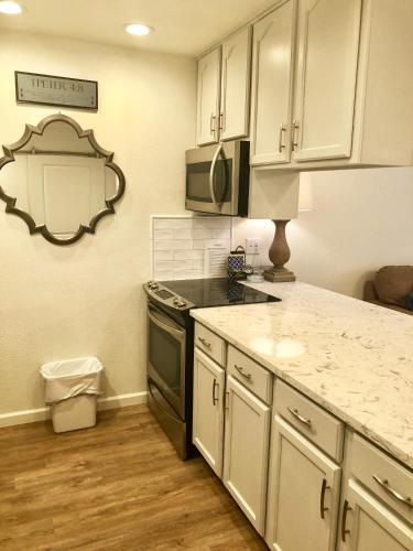 a kitchen with white cabinets and a black stove at Comal Haus in New Braunfels