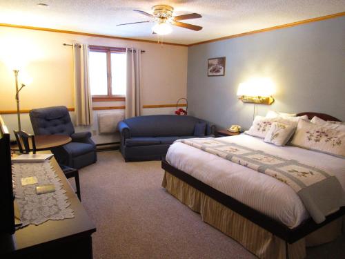 a bedroom with a bed and a couch and a chair at Carlson's Lodge in Twin Mountain