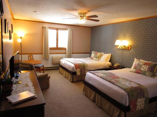 a hotel room with two beds and a desk at Carlson's Lodge in Twin Mountain