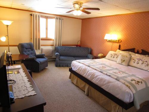 a bedroom with a bed and a couch and a chair at Carlson's Lodge in Twin Mountain