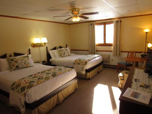 a hotel room with two beds and a window at Carlson's Lodge in Twin Mountain