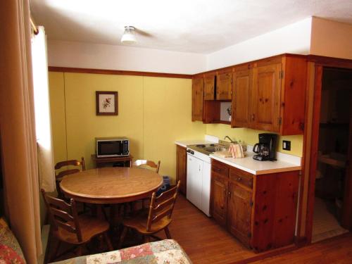 a kitchen with a wooden table and a kitchen with a table and chairs at Carlson's Lodge in Twin Mountain