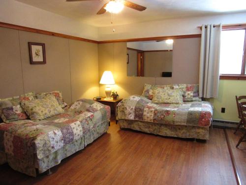 a living room with two beds and a couch at Carlson's Lodge in Twin Mountain