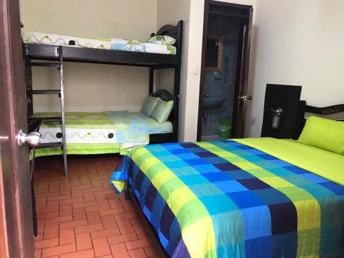 a bedroom with two bunk beds and a door at Hotel Krone in Popayan