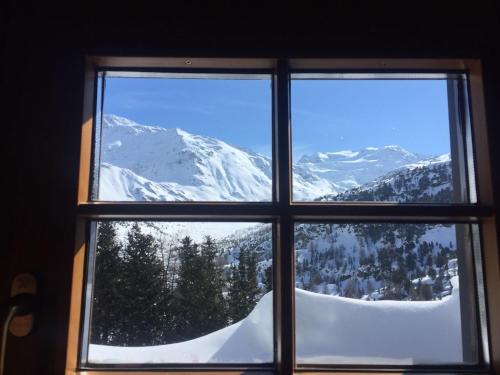 a window with a view of a snow covered mountain at Rifugio Ghiacciaio dei Forni in Valfurva