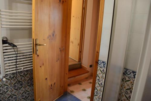 a bathroom with a wooden door and a staircase at appartamento in Pantelleria