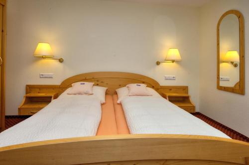 two twin beds in a room with a mirror at Gasthaus Sonne in Münstertal
