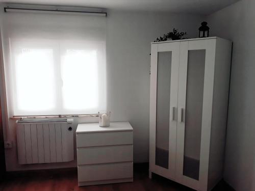 a room with a white cabinet and a window at Apartamento El Sauce de Amalia in Celorio