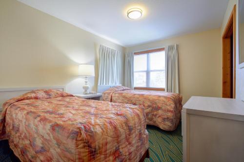 a hotel room with two beds and a window at Ocean Pines Resort in Duck