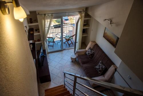 a living room with a couch and a balcony at Apartments Klakor PS in Tivat