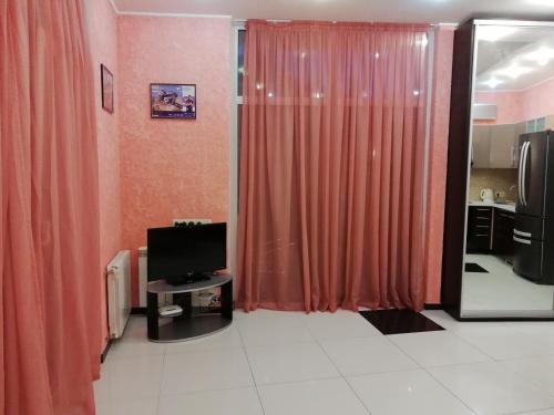 Petropavlovskaya Borshchagovka的住宿－Таунхаус 99，客厅配有橙色窗帘和电视