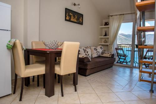 a living room with a table and chairs and a couch at Apartments Klakor PS in Tivat