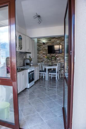 a kitchen and dining room with a table and chairs at Apartments Klakor PS in Tivat