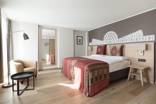 
a bedroom with a bed and a dresser at Hotel Steffani in St. Moritz

