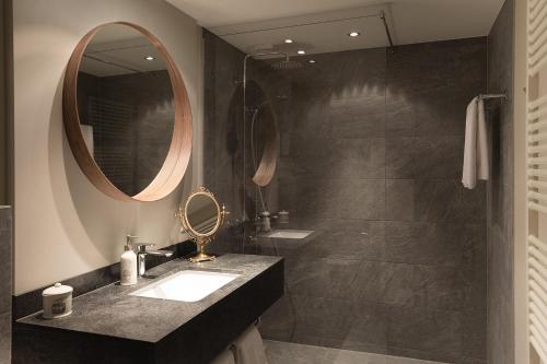 a bathroom with a sink and a mirror at Hotel Steffani in St. Moritz