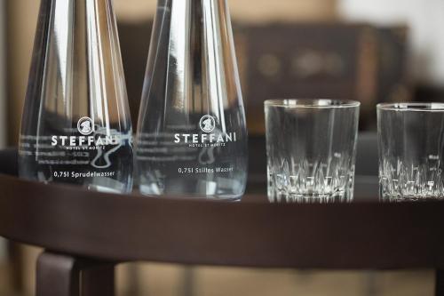 three empty wine glasses sitting on a table at Hotel Steffani in St. Moritz