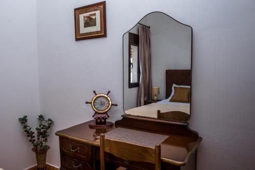 a bedroom with a mirror and a table with a clock at Apartments Klakor PS in Tivat