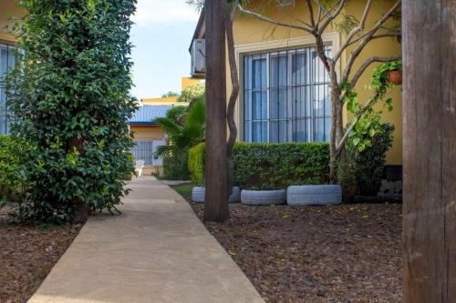 a sidewalk in front of a building with trees at El Sueño de Pedro - Pileta Climatizada in Colón