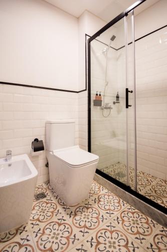 a bathroom with a toilet and a glass shower at FAUNA Montevideo in Montevideo