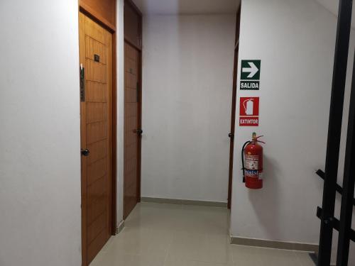 a hallway with a fire extinguisher sign on the wall at Hospedaje Villa Del Sol in Ica