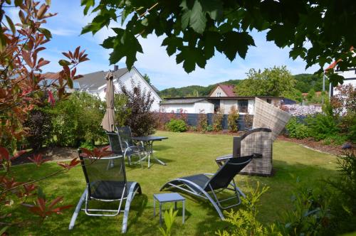 a group of chairs and an umbrella in a yard at Urlaubsdomizil InselLust-Rügen in Sassnitz