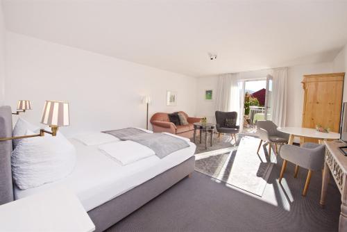 Landhotel Herzberger garni Zimmer & Ferienwohnungen في شايديغ: غرفة نوم مع سرير وغرفة معيشة