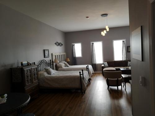 a bedroom with two beds and a living room at Canalside Restaurant & Inn in Port Colborne