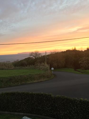 a winding road with a sunset in the background at Casa do Campo in Cedros