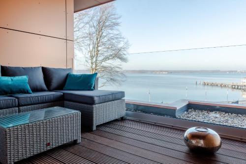 a living room with a couch and a view of the water at Intermar Hotel & Apartments in Glücksburg