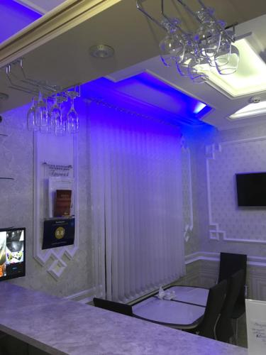 ピャチゴルスクにあるGuesthouse Prestigeの紫色の照明、テーブルと椅子が備わる客室です。