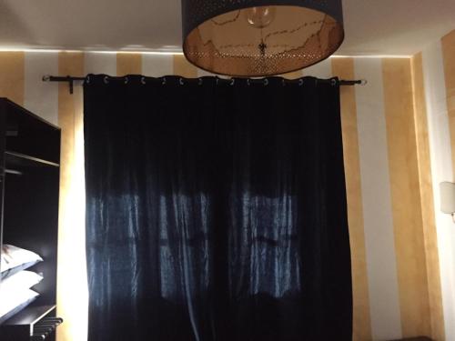 a black curtain and a chandelier in a room at FiumicinoA57 in Fiumicino