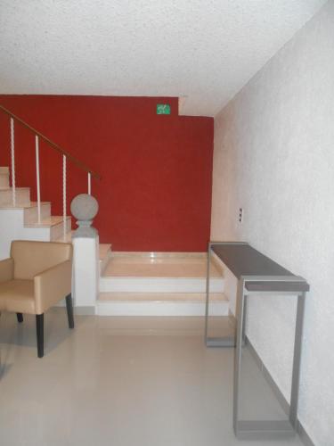 a room with stairs and a table and a red wall at Hotel Puente Real in Puebla