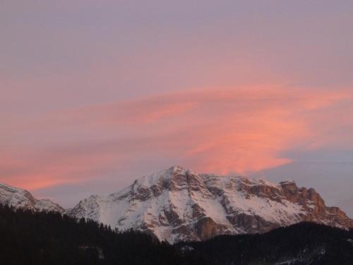 a mountain covered in snow with a pink sky at Chalet Morin in San Martino in Badia