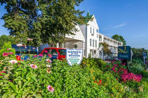 a sign in a garden of flowers in front of a building at Quality Inn Eureka Springs South in Eureka Springs
