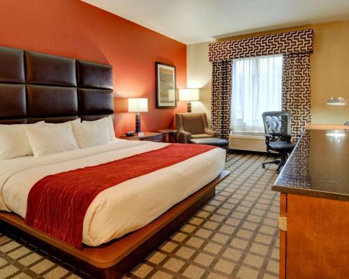 ein Hotelzimmer mit einem großen Bett und einem Schreibtisch in der Unterkunft Comfort Inn & Suites Fort Smith I-540 in Fort Smith