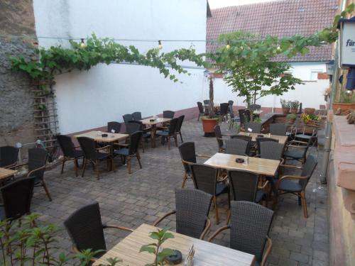 an outdoor patio with tables and chairs and trees at Gasthaus zum Lamm in Ettenheim