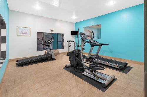 un gimnasio con cintas de correr y elípticas en una habitación en Howard Johnson by Wyndham Holbrook, en Holbrook