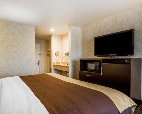 a hotel room with a bed and a flat screen tv at Comfort Inn Watsonville in Watsonville
