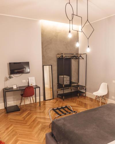 a room with a bed and a desk and a tv at Relais Della Porta in Naples