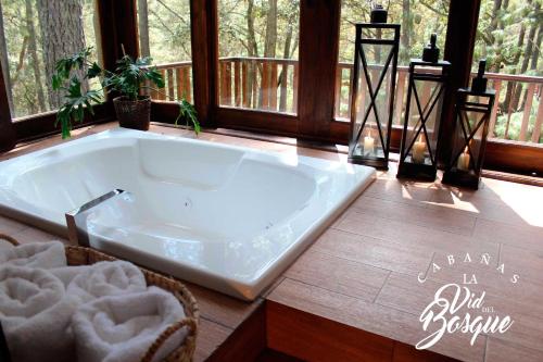 bañera grande en una habitación con ventanas en Cabañas La Vid Del Bosque en Tapalpa